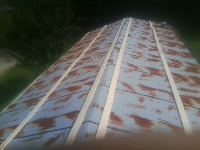 Rusted metal roof panels with new wood purlins before replacement — Storm Damage Roof Repair in Swoope by Roofing Brothers