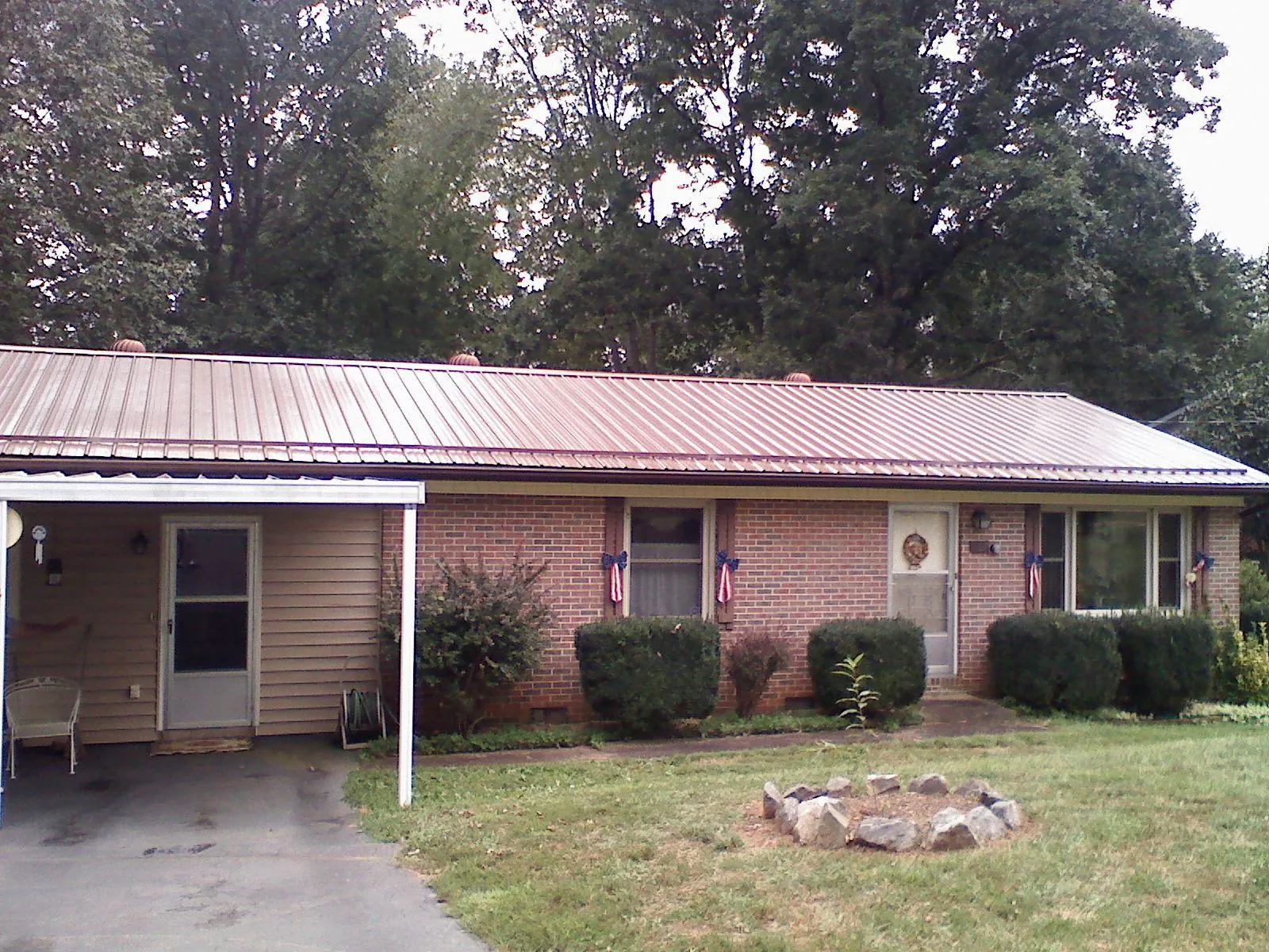Bronze metal roof and carport on a brick ranch home — Roof Repair work by our crew in Swoope